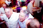 Groom and his brother enjoy the wedding band at the Sand Banks Hotel wedding photography by jonathan Lappin